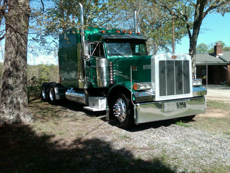 Green Peterbilt conventional sleeper tractor with polished chrome